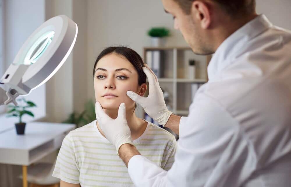 Client consulting with skincare specialist about microdermabrasion for acne scars at medical spa.