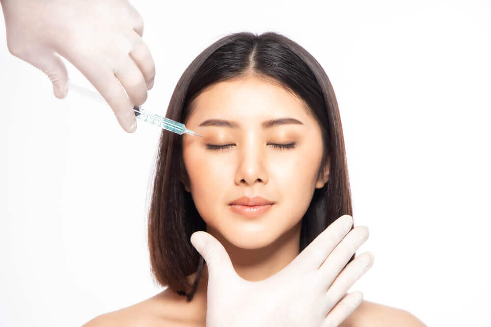 Cosmetic provider administering Botox injections into forehead muscles using fine needle