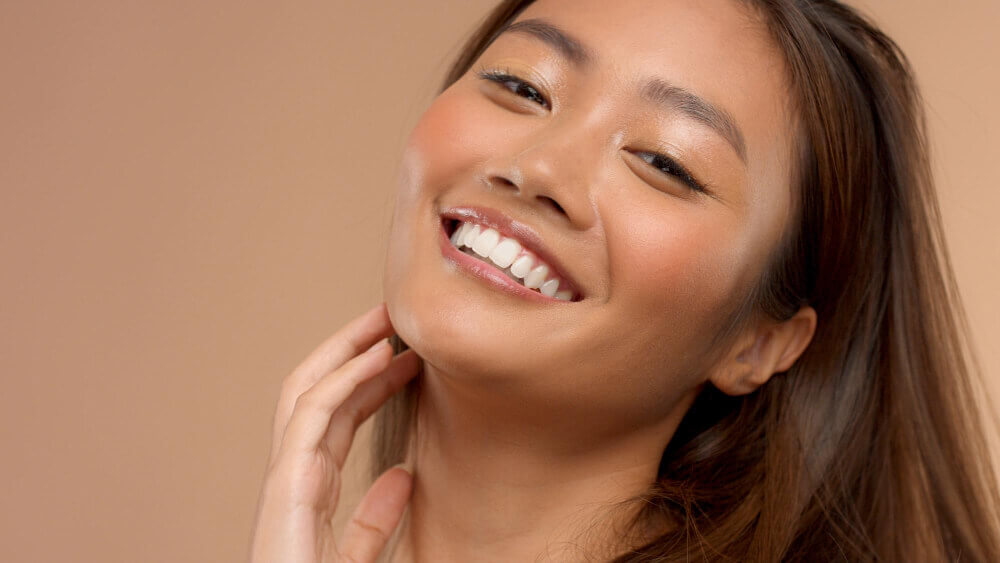 Happy woman with refreshed and natural-looking facial appearance after smile line fillers.